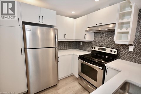 A modern kitchen with a stainless steel refrigerator and oven.