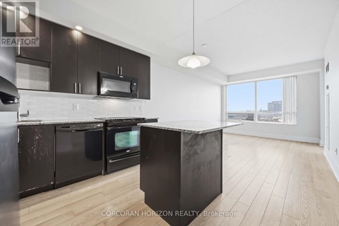 A modern kitchen with black cabinets and a large island.