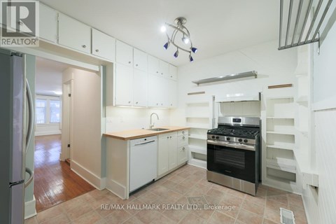 A kitchen with white cabinets and a black stove top oven.