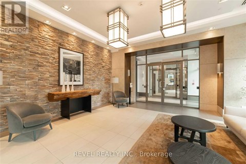 A modern living room with a stone wall and a glass door.