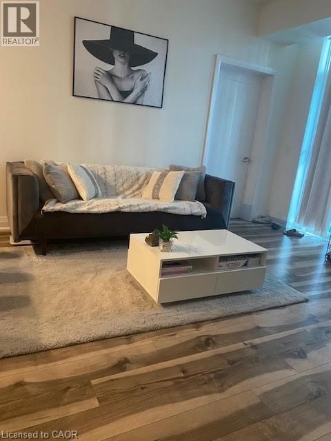 A living room with a couch, a coffee table, and a painting on the wall.