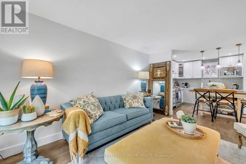 A living room with a grey couch and a yellow rug.