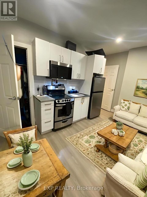 A kitchen with white cabinets and a wooden table with green plates on it.