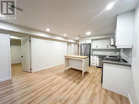 A kitchen area with a table and a refrigerator.