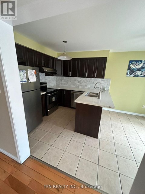 A kitchen with black cabinets and a white refrigerator.