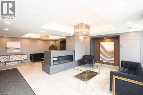 A modern living room with a black leather sofa and a glass coffee table.