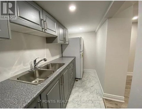 A kitchen with a sink and a refrigerator.