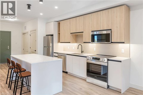 A modern kitchen with wooden cabinets and stainless steel appliances.