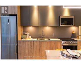 A modern kitchen with a refrigerator and a sink.