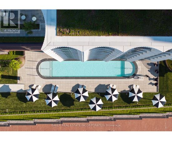 An aerial view of a pool surrounded by umbrellas and a building with the logo "TR" on it.