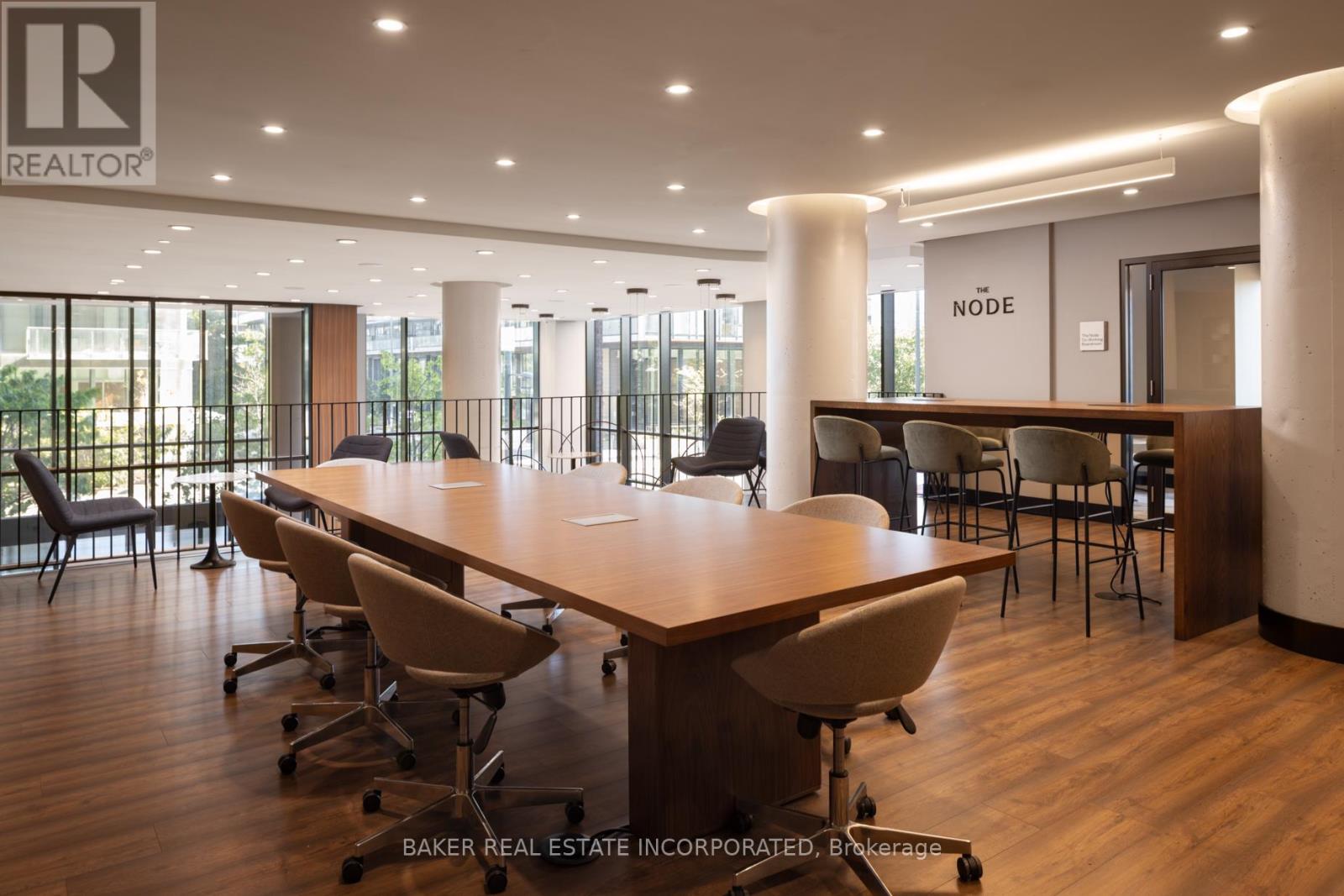 A conference room with a long table and chairs, and a sign that reads "REALTOR".