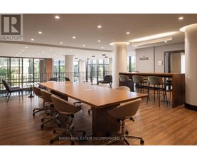 A conference room with a long table and chairs, and a sign that reads "REALTOR".