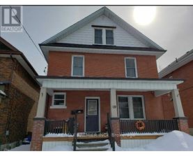 A house with a black door and a sign that says RE/MAX Premier Realty.