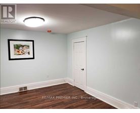A room with a white door and a picture on the wall.