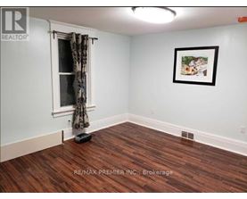 A room with a window and a picture on the wall.