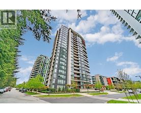 A tall residential building with a glass facade stands in the foreground of a sunny street.