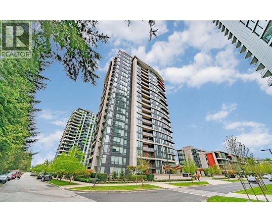 A tall residential building with a glass facade stands in the foreground of a sunny street.