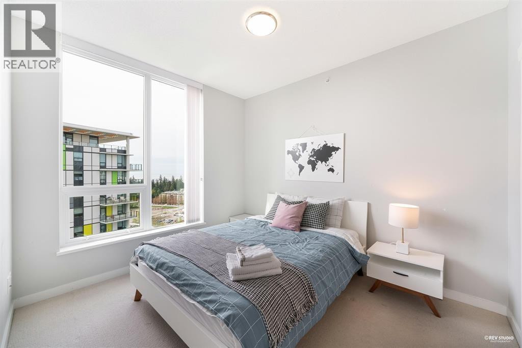 A bedroom with a large bed and a window overlooking a building.