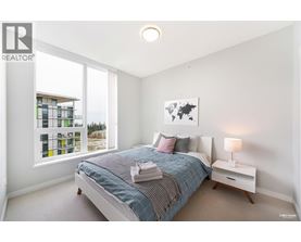 A bedroom with a large bed and a window overlooking a building.