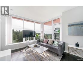A living room with a grey couch and a large window.