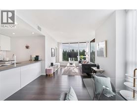 A modern living room with a kitchen area in the background.