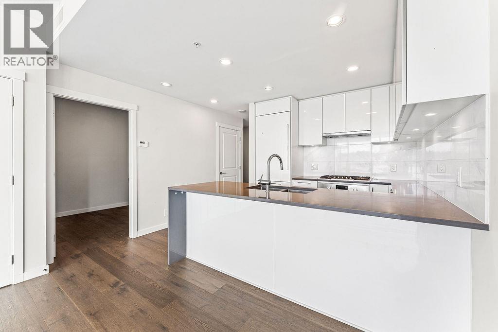 A modern kitchen with white cabinets and a wooden island.