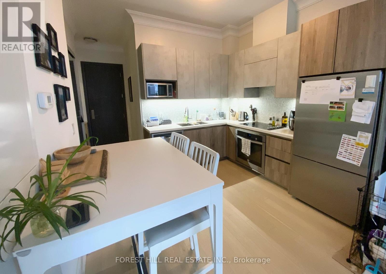 A kitchen with a white table and a refrigerator.
