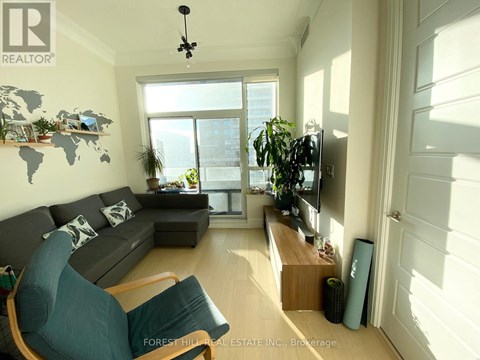 A living room with a grey couch and a green chair.
