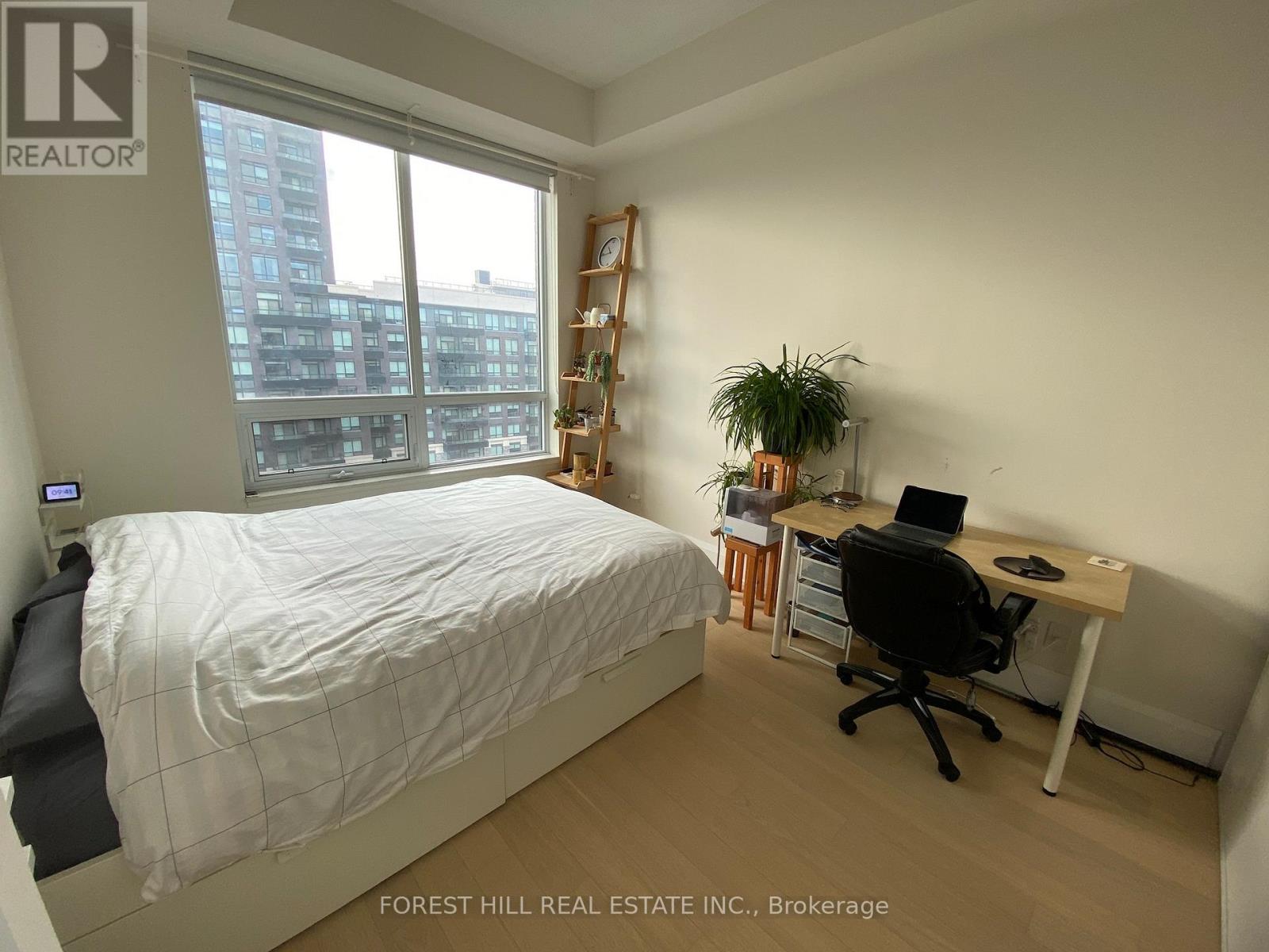A bedroom with a bed, desk, and chair.