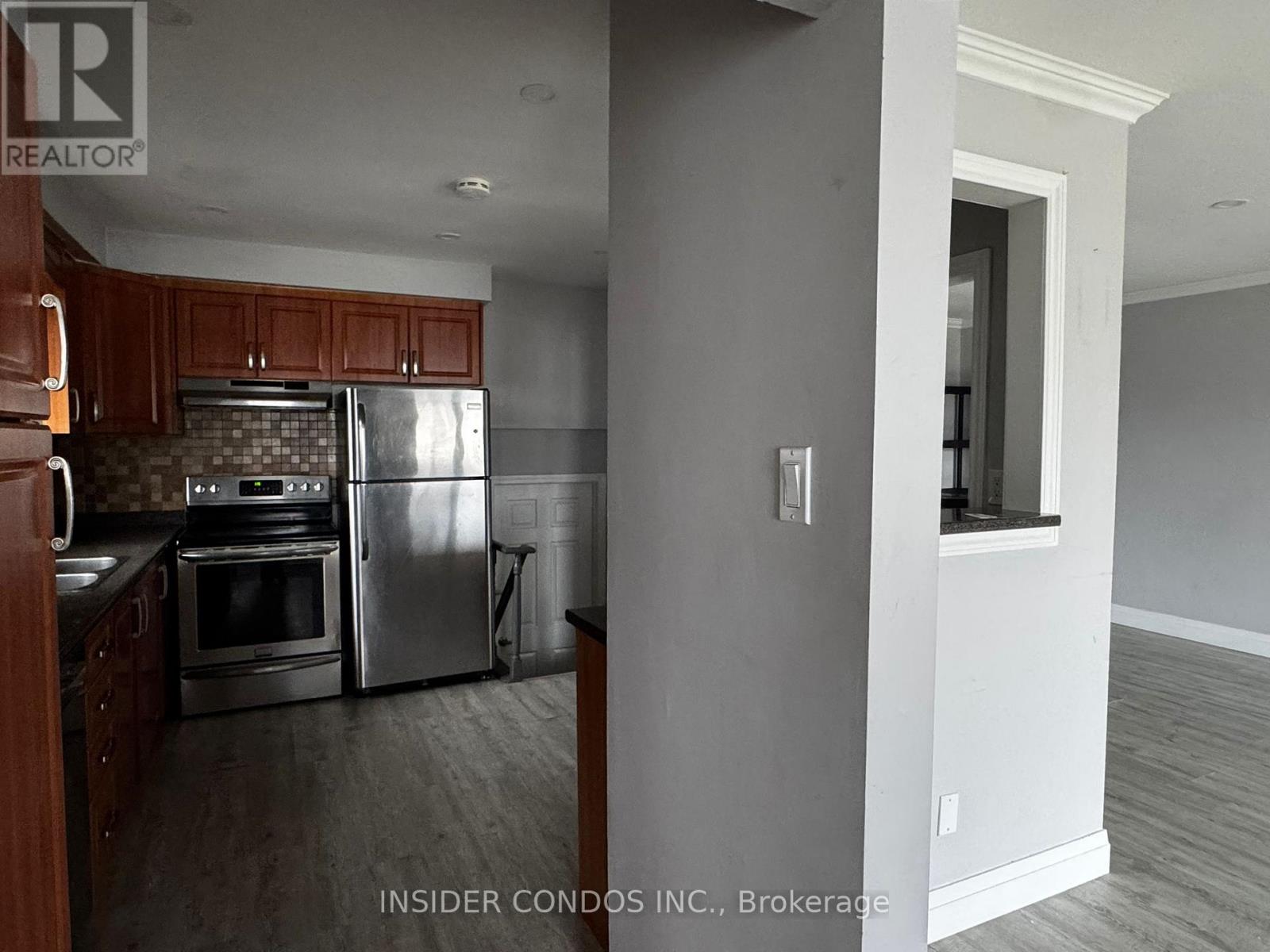 A kitchen with a stainless steel refrigerator and oven.
