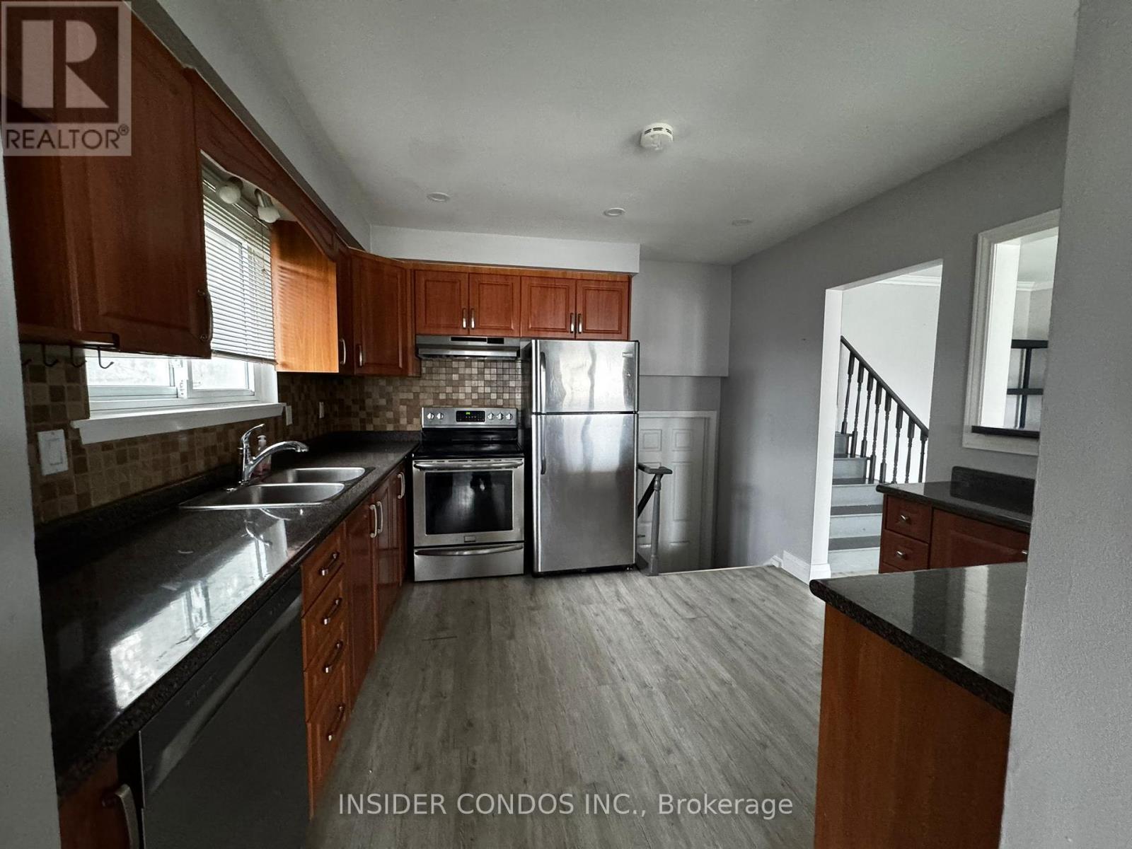 A kitchen with wooden cabinets and stainless steel appliances.