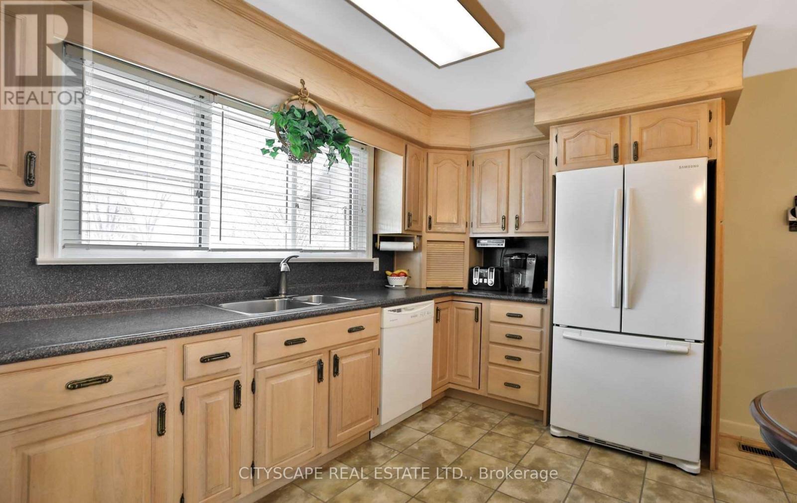 A kitchen with wooden cabinets and a white fridge.