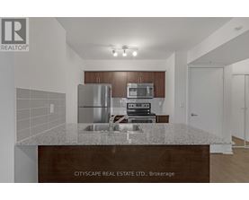 A kitchen with a granite countertop and stainless steel appliances.