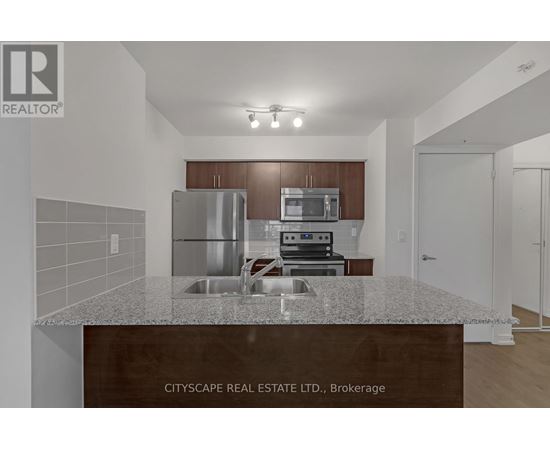 A kitchen with a granite countertop and stainless steel appliances.
