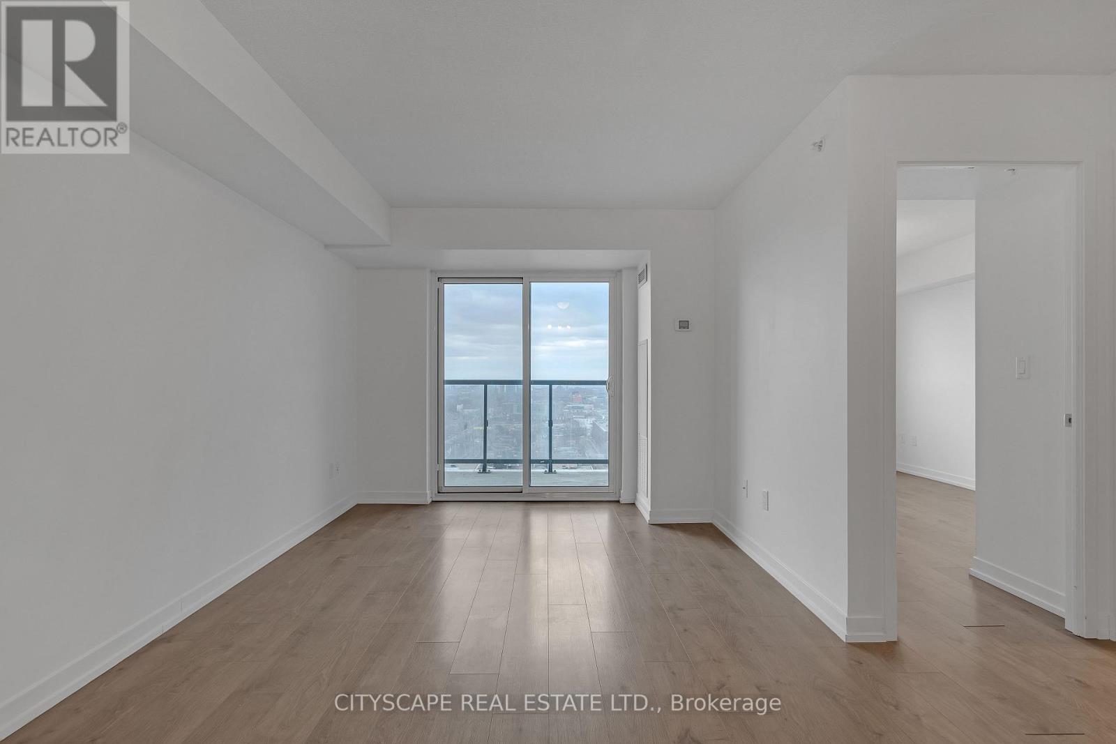A large empty room with a view of the city through a glass door.