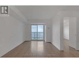A large empty room with a view of the city through a glass door.