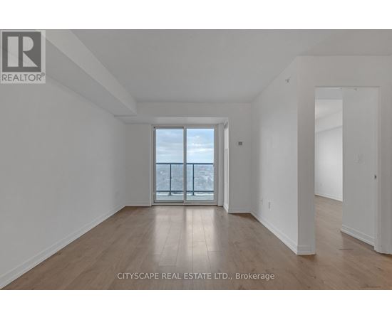 A large empty room with a view of the city through a glass door.
