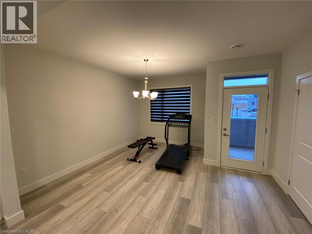 A room with a treadmill and a window with blinds.