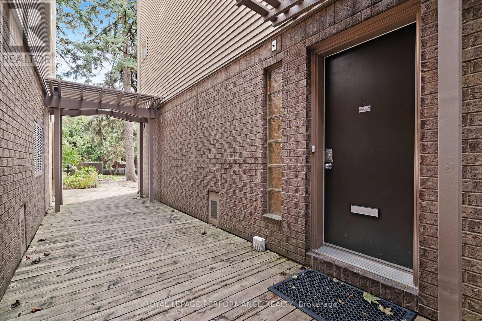 A brick building with a wooden door and a covered walkway.