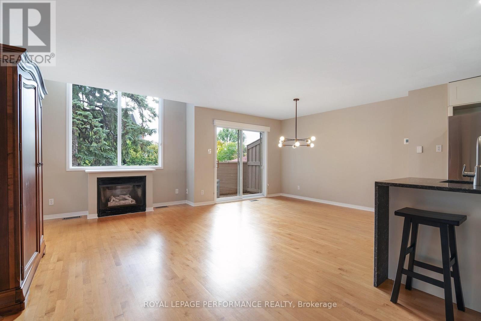 A spacious room with a fireplace and a bar stool.