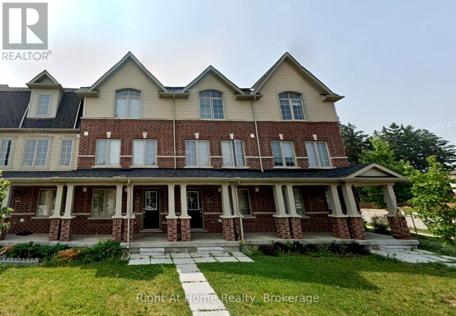 A large, two-story house with a brick facade and a large front porch.
