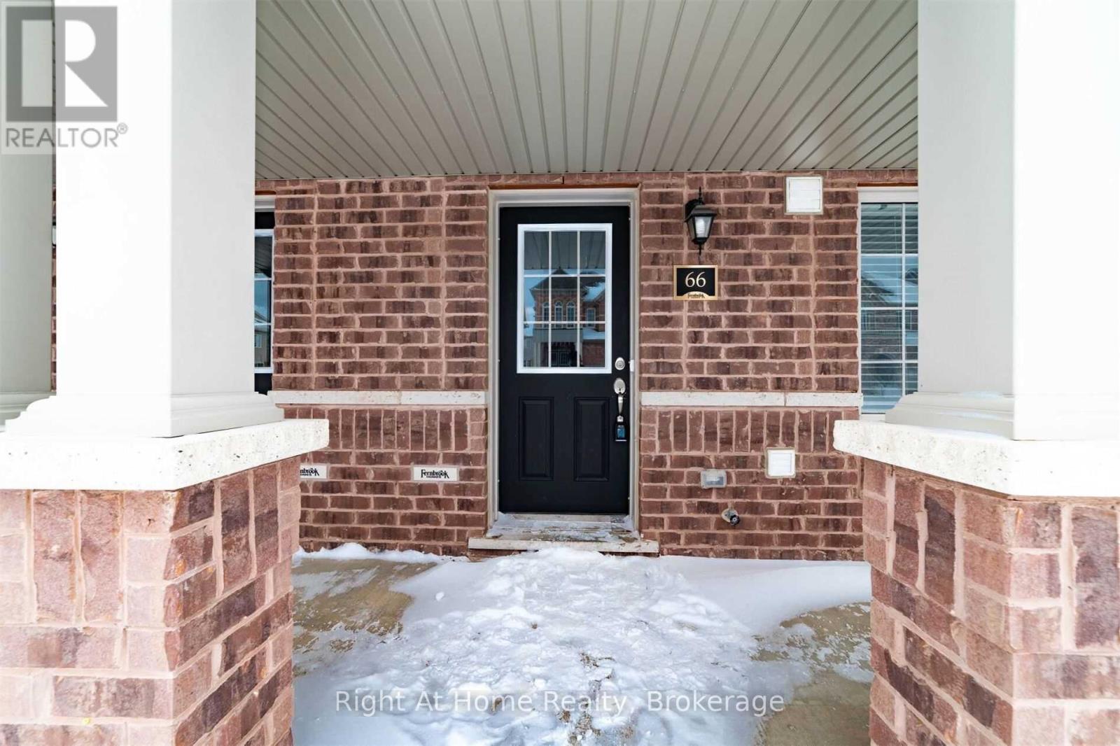 A black door is on the brick house.