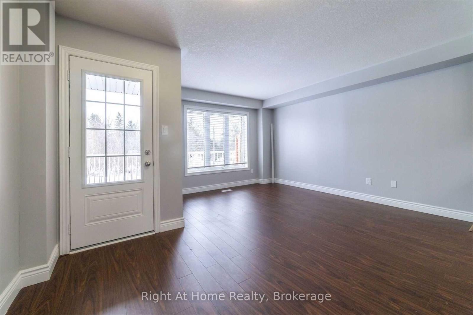 A room with a door and a window with a view of a building outside.