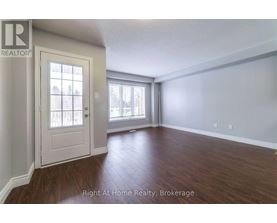 A room with a door and a window with a view of a building outside.