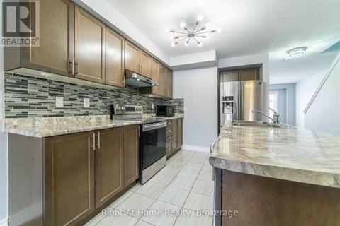 A kitchen with brown cabinets and a marble countertop.