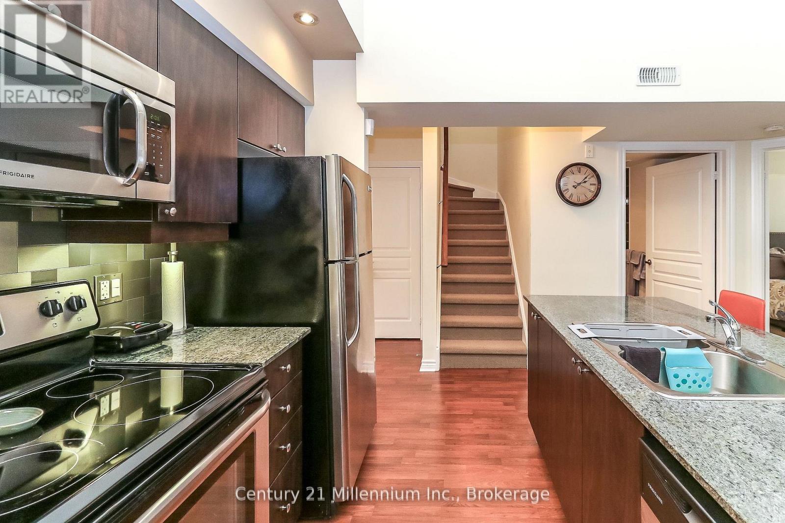 A kitchen with a stove top oven and a refrigerator.