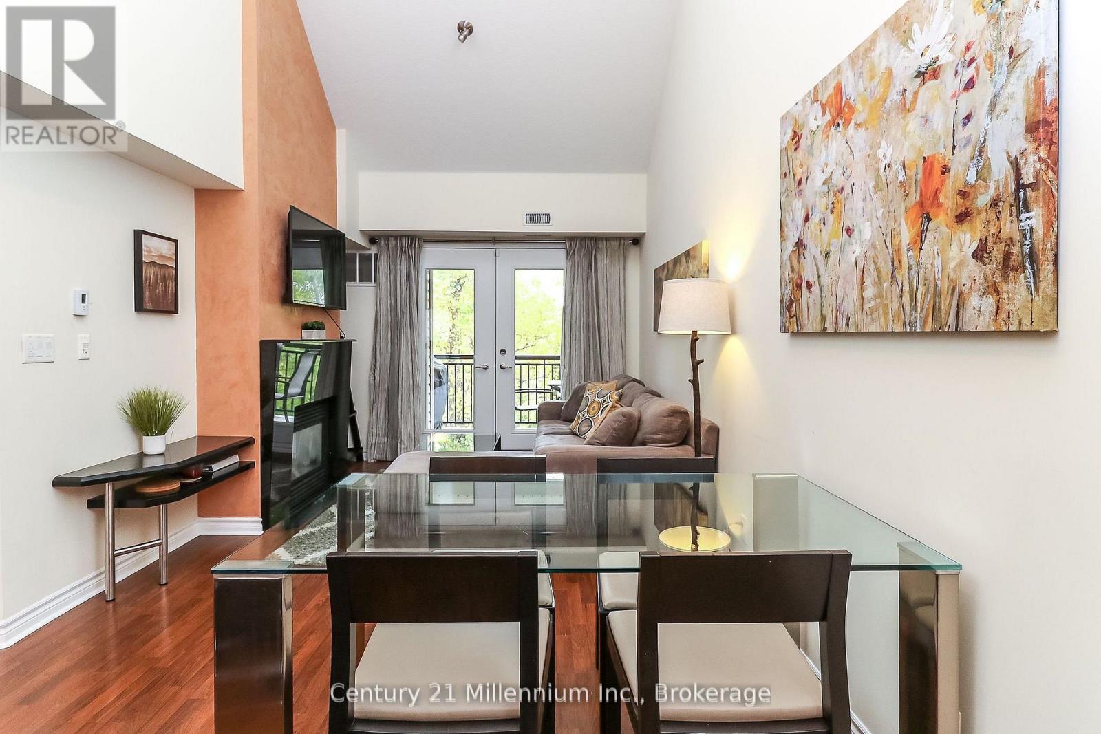 A modern dining room with a glass table and chairs.