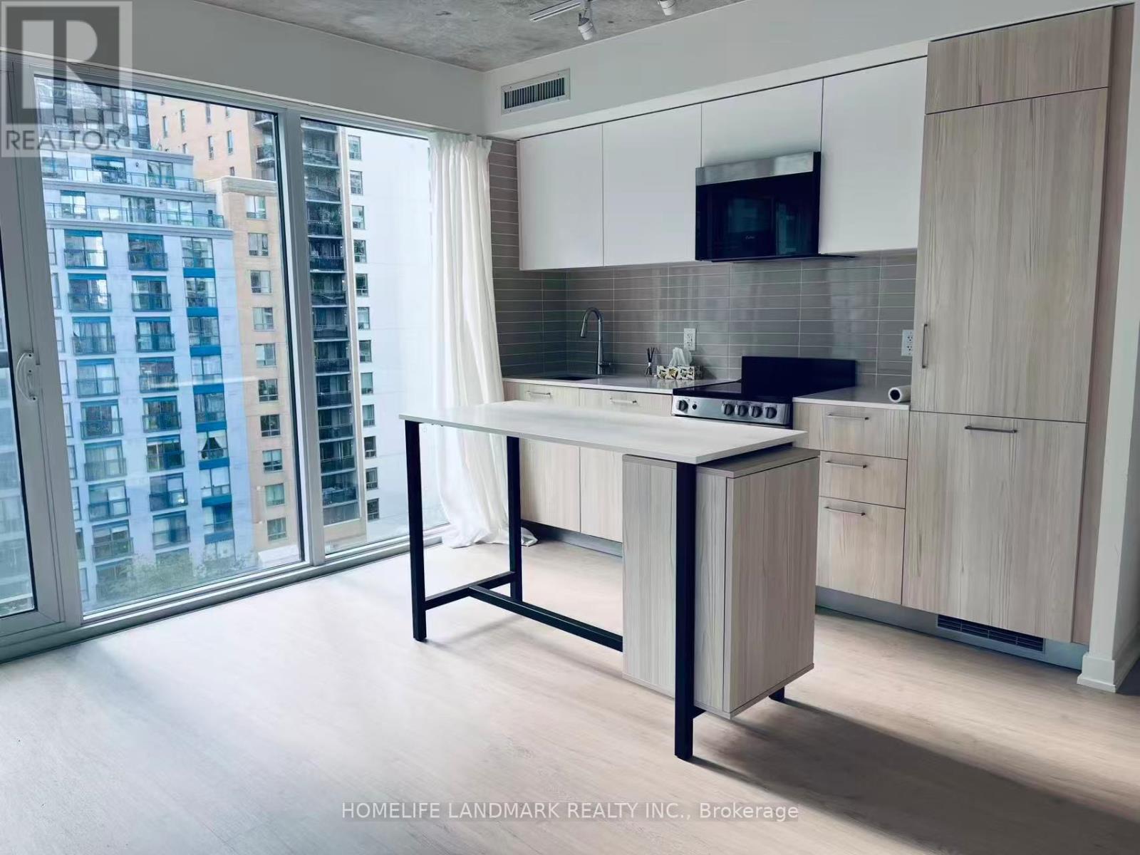 A kitchen with a table and chairs in front of a window with a view of a city.