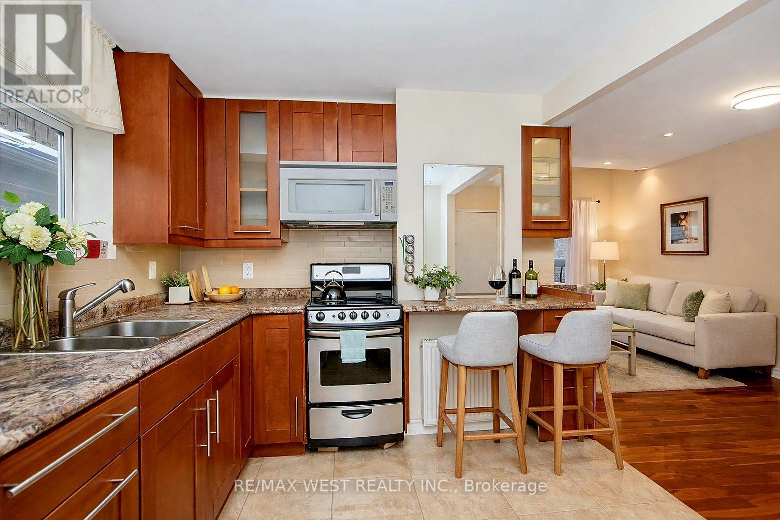 A kitchen with wooden cabinets and a stove top oven.