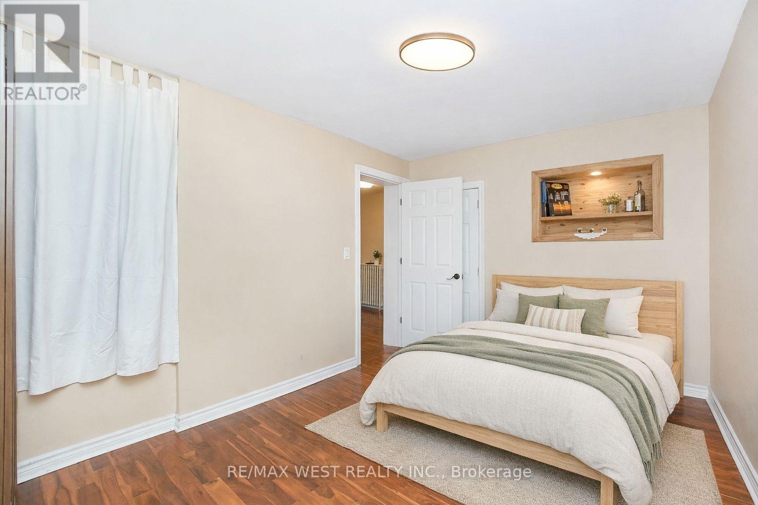 A bedroom with a bed, nightstand, and a small bar area in the corner.